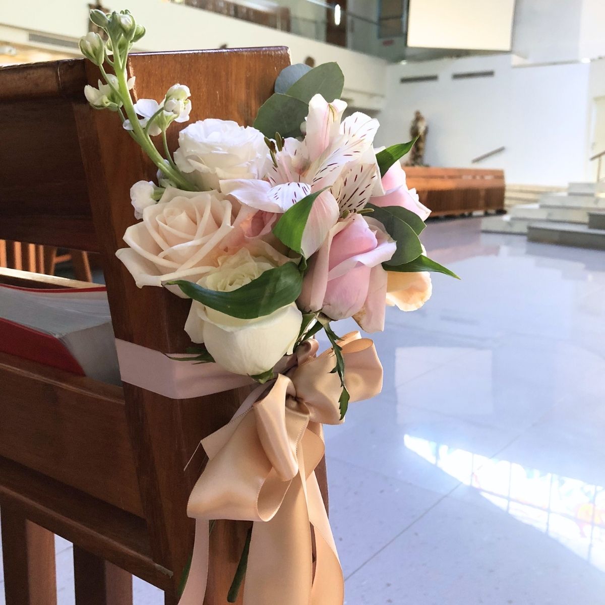 Church aisle pew ties white roses blush ribbon ceremony Singapore